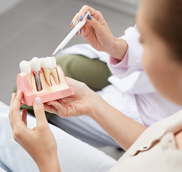 a dentist showing how dental implants work